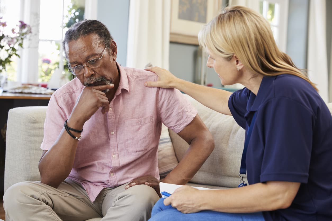 Man looking concerned while woman therapist tries to comfort him