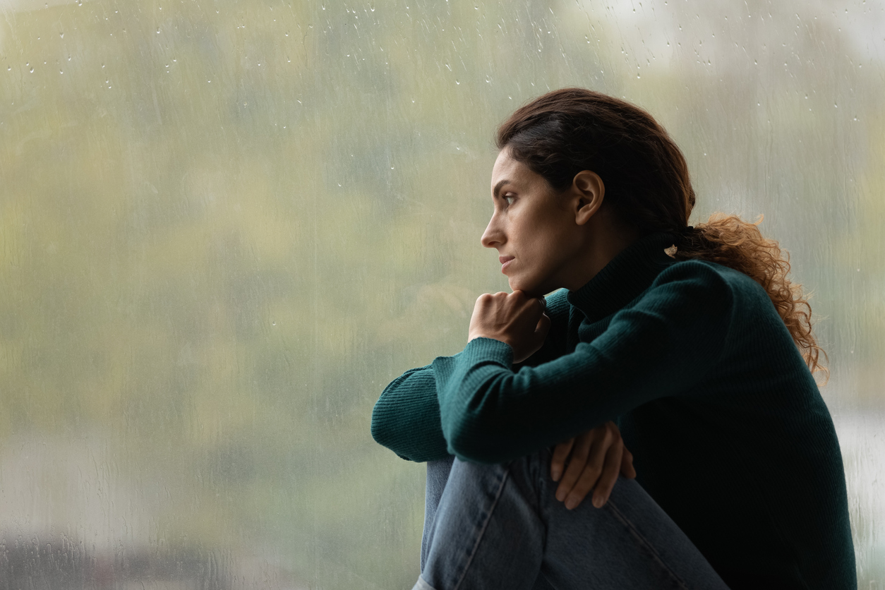 Personality Disorders - a photograph of a woman looking out rainy window 