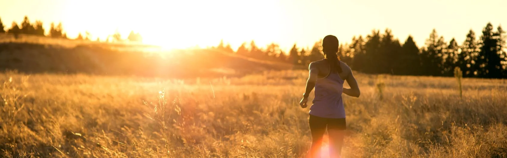 How to Flush Alcohol Out of Your System - an image of a woman going for a run in a open field during sunset