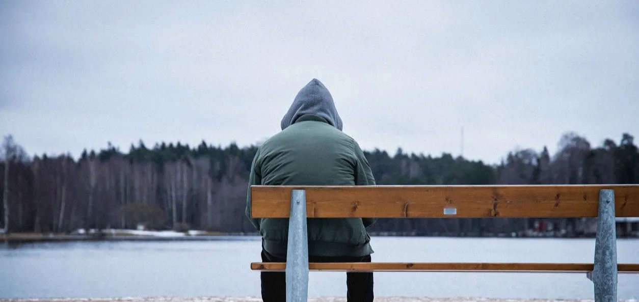 Man with seasonal affective disorder outside on bench