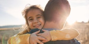 little girl hugging her parent in the sun