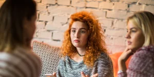 woman looking serious with two other friends
