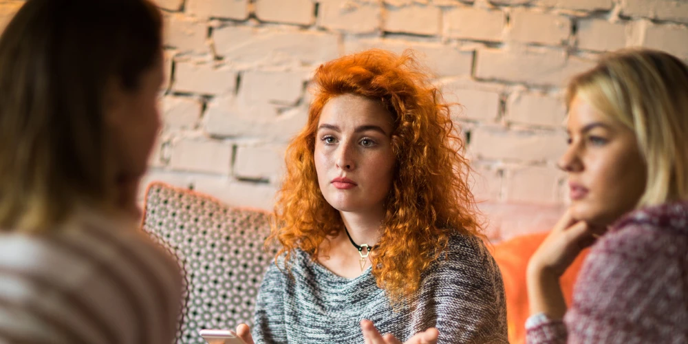 woman looking serious with two other friends