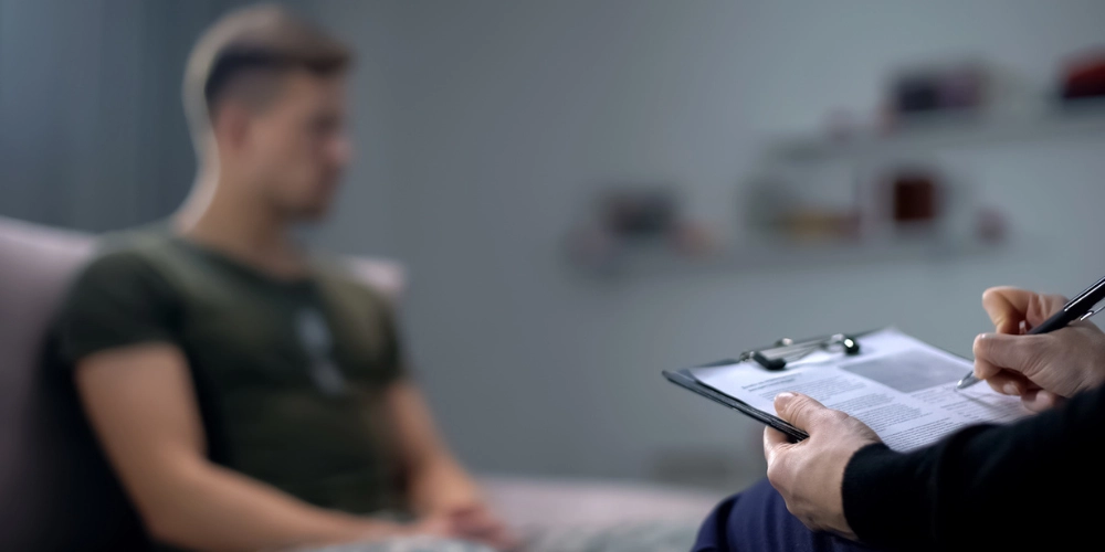 Can Cocaine Cause Psychosis? An image of a man sitting in an mental health assessment