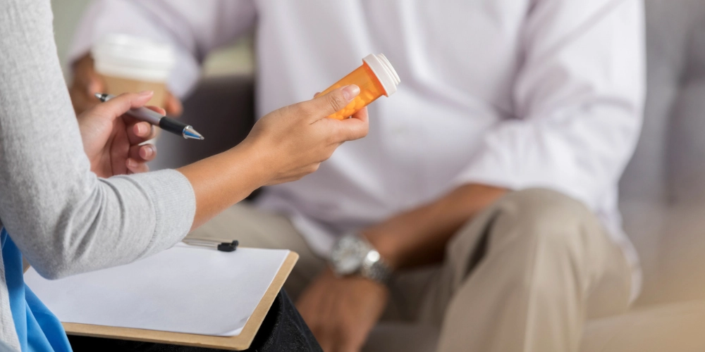 a female mental health professional explains to a male patient the side effects of an antidepressant medication