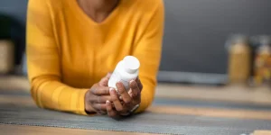 A woman holding vitamin D bottle